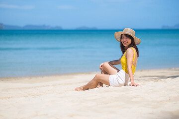 Woman tourist in yellow swimsuit and hat, happy traveler sunbathing at Paradise beach on Islands....