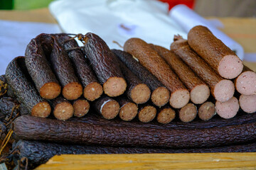 pieces of dried, smoked sausage at a farmer's market. handmade