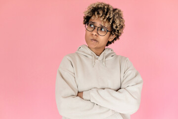 Attentive African American woman. Female model in glasses with curly hair thinking. Portrait, studio shot, emotion concept