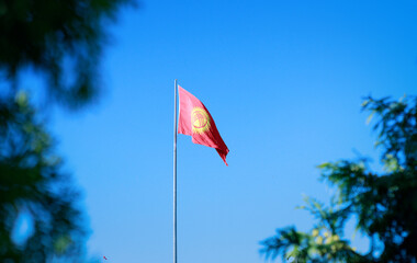 Kyrgyzstan Flag Looping Background fluttering in the wind against a blue sky . High quality photo