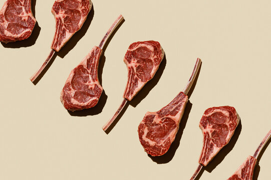 Horizontal Pattern of Raw fresh meat Tomahawk Steak on beige background flatlay food