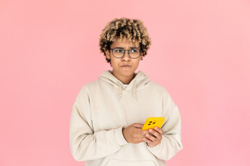Portrait of frowning African American woman with phone. Female model in glasses with curly hair looking up. Portrait, studio shot, emotion concept