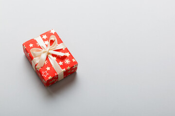 Wrapped christmas or other holiday handmade present in paper with colored ribbon. Present box, decoration of gift on table, top view with copy space