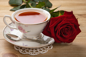 breakfast concept. a cup of tea and a red rose on the table