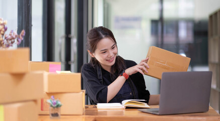 Starting a small business, SME owner, female entrepreneurs are using the rope to tie boxes to pack products Order online to prepare to pack a box of goods for sale to customers, sme business idea