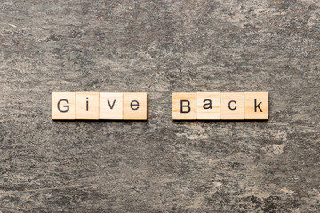 Give Back word written on wood block. Give Back text on table, concept