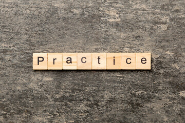 practice word written on wood block. practice text on table, concept