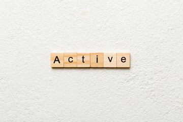active word written on wood block. active text on table, concept