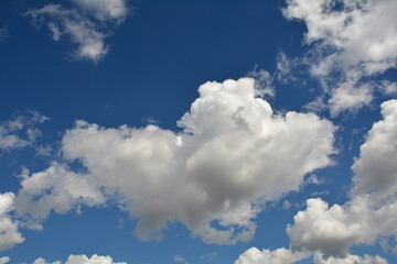 Naklejka na ściany i meble White, fluffy clouds in blue sky. Background from clouds.