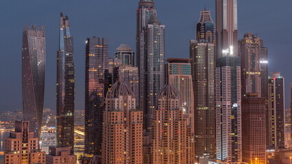 Fototapeta na wymiar Skyscrapers of Dubai Marina near intersection on Sheikh Zayed Road with highest residential buildings night to day timelapse