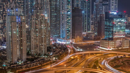 Fototapeta na wymiar Aerial view on Dubai Marina with big highway intersection night timelapse and skyscrapers around, UAE