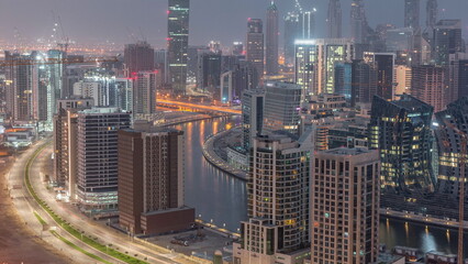 Obraz na płótnie Canvas Skyline with modern architecture of Dubai business bay towers night to day timelapse. Aerial view