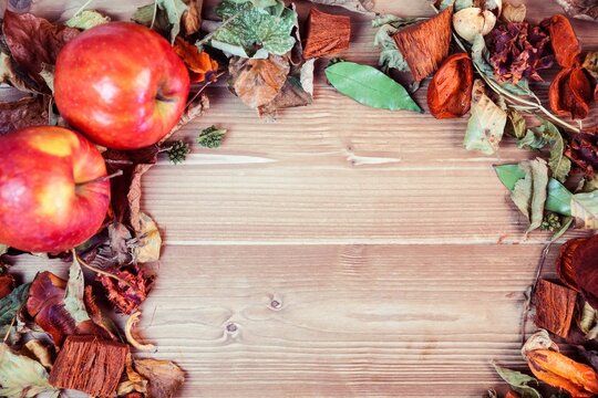 High angle view of apples with dry leaves on table