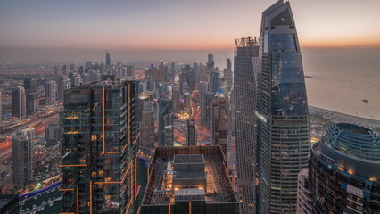 Skyline panoramic view of Dubai Marina showing canal surrounded by skyscrapers along shoreline day to night timelapse. DUBAI, UAE