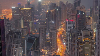 View of Dubai Marina showing canal surrounded by skyscrapers along shoreline night to day timelapse. DUBAI, UAE