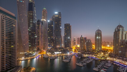 Fototapeta na wymiar Dubai marina tallest skyscrapers and yachts in harbor aerial night to day timelapse.