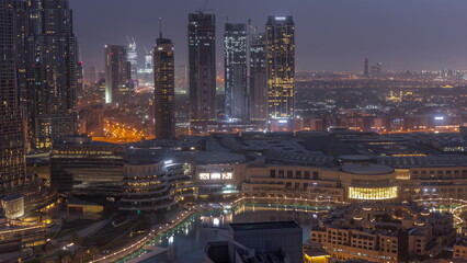 Obraz premium Dubai downtown with fountains and modern futuristic architecture aerial night to day timelapse