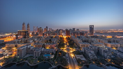 Panorama of skyscrapers in Barsha Heights district and low rise buildings in Greens district aerial night to day timelapse.