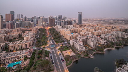 Obraz premium Skyscrapers in Barsha Heights district and low rise buildings in Greens district aerial day to night timelapse.