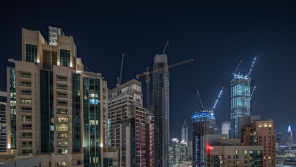 Fototapeta na wymiar Panorama showing aerial cityscape night timelapse with illuminated architecture of Dubai downtown.