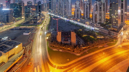 Obraz premium Bay Avenue with modern towers residential development in Business Bay aerial panoramic night to day timelapse, Dubai