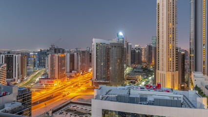 Skyscrapers at the Business Bay in Dubai aerial night to day timelapse, United Arab Emirates