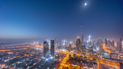 Naklejka premium Aerial view of tallest towers in Dubai Downtown skyline and highway night to day timelapse.