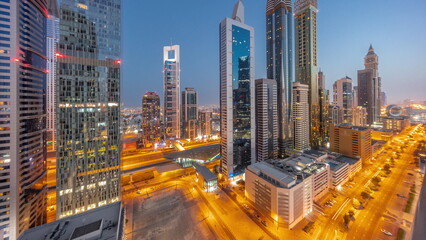 Fototapeta na wymiar Aerial view of Dubai International Financial District with many skyscrapers night to day timelapse.