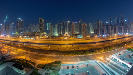 Panoraama of Dubai Marina skyscrapers and Sheikh Zayed road with metro railway aerial night to day timelapse, United Arab Emirates