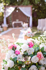 a pergola decorated with white sashes and a rug with vases of flowers for a wedding