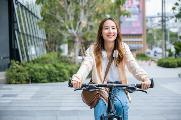 Obraz na płótnie Canvas Happy Asian young woman riding bicycle on street outdoor near building city, Portrait of smiling female lifestyle use mountain bike in summer travel means of transportation, ECO friendly, Urban biking