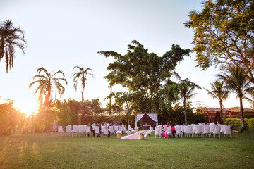a pergola decorated with white stripes and a rug with flower pots for a wedding and chairs with...