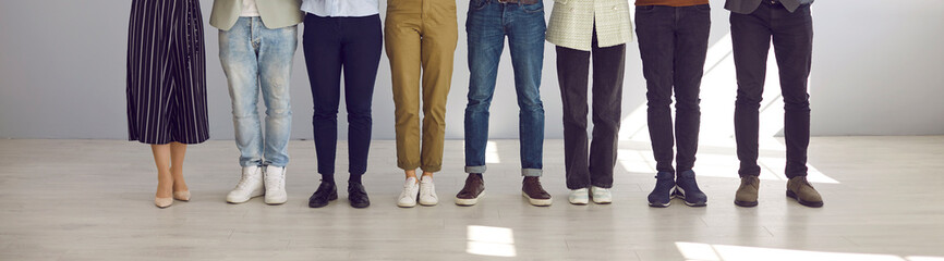 Cropped indoor low section shot of people's legs. Group of employees of different sexes and genders...