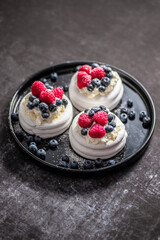 Mini Pavlova cakes topped with berries and mascarpone cheese
