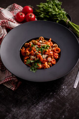 Tasty appetizing classic italian pasta with tomato sauce, cheese parmesan and basil on plate