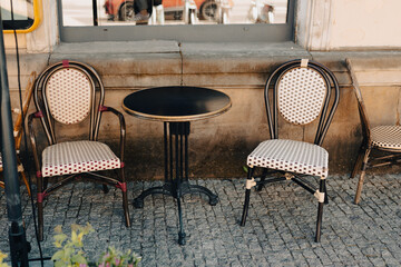 Empty tables in between dining hours. Old fashioned cafe terrace in a summer warm day