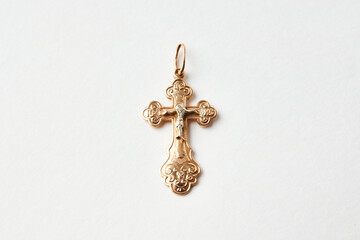 Gold cross on a white background, close-up