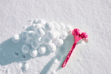 A children toy is a tool for modeling snowballs from snow. Red color plastic device. Winter outdoor kids games. Active leisure gift. Snowy background. Copy space. Banner. Ice forceps. New year time