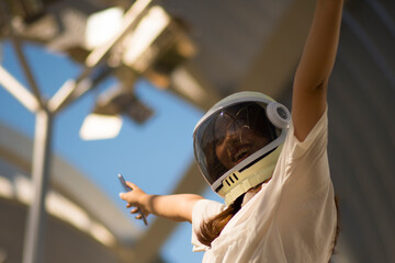 Girl posing dressed in astronaut helmet