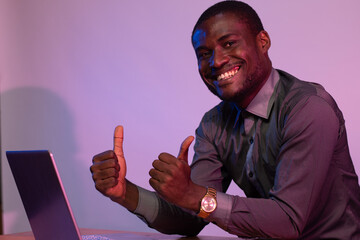 african man using his laptop smiling and does thumbs up