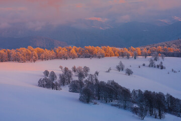 Winter mountan landscape. Bright sunset over snow-covered mountain range.