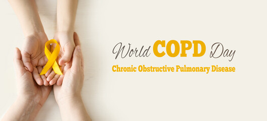 World COPD day. Medical campaign against Chronic Obstructive Pulmonary Disease in november. Woman's and child's hands hold an orange ribbon