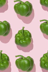 Pattern of fresh green peppers on pink background. Minimal concept.