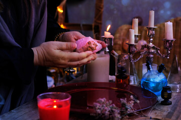 healing session in the salon of healer, herbalist, close-up of hands of female psychic hold rose...
