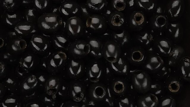 Black olives top view, rotate. Pitted olives 