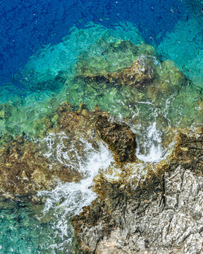 Luftaufnahme von gegen einen Stein schlagende Wellen © Philipp