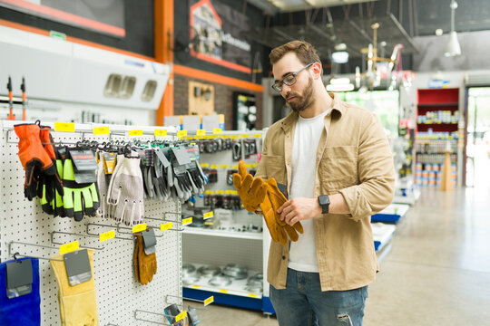 Construction worker at the hardware store shopping for security gloves