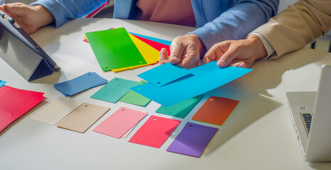 business people choose color during brainstorming in the office. close up of partners colleagues hands during meeting with color palettes. color choice for future product construction idea.