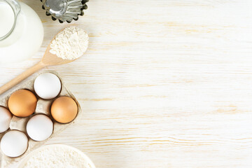 Baking cooking Ingredients background with copy space. Flour, eggs, milk, bakeware on white wooden surface. Top view, flat lay. Mockup menu, banner, header for site, baking concept
