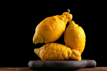 Juicy deformed lemons on dark background, close-up. Trend - eating ugly fruits and vegetables....